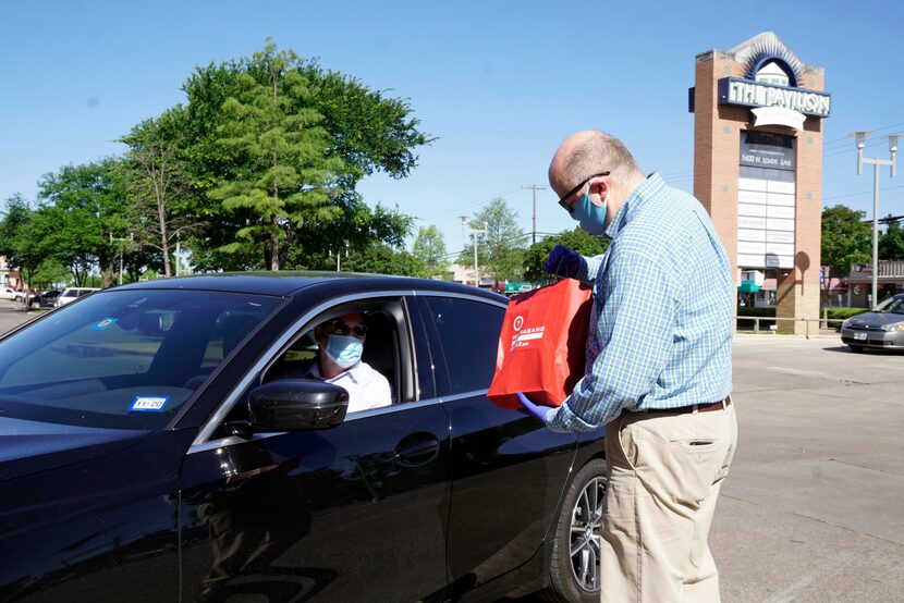 Interabang Books manager and partner Kyle Hall delivers books curbside to Joe Gall at the...