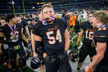 Aledo offensive lineman Cameron Callaway (54) bites his gold medal as he and his team...