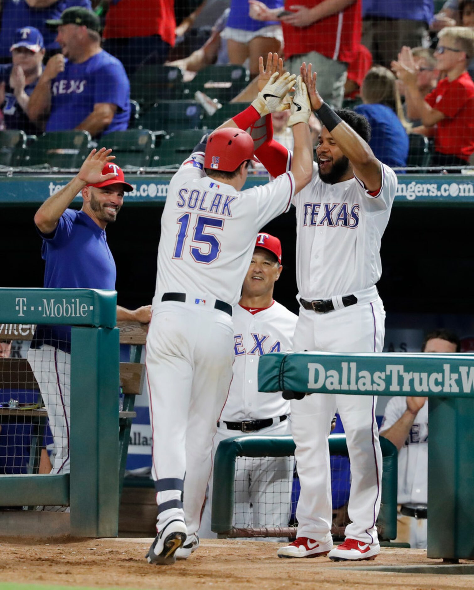 Texas Rangers' Nick Solak (15) is congratulated by manager Chris Woodward, left, and Elvis...