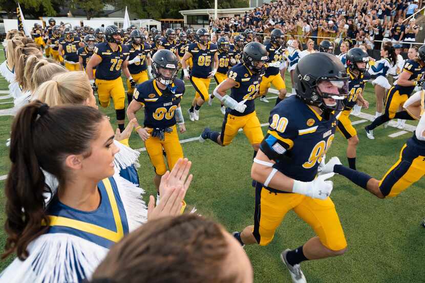 Highland Park football players run on to the field for their Friday night high school game...