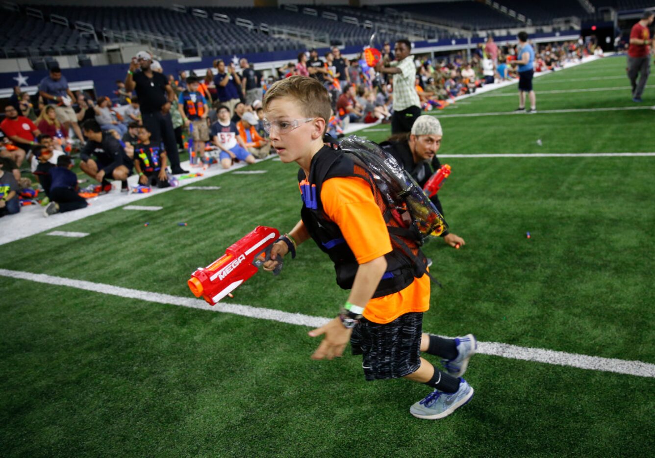 Kyson Henderson, 9, runs with a Nerf gun during Jared's Epic Nerf Battle 2 at AT&T Stadium...