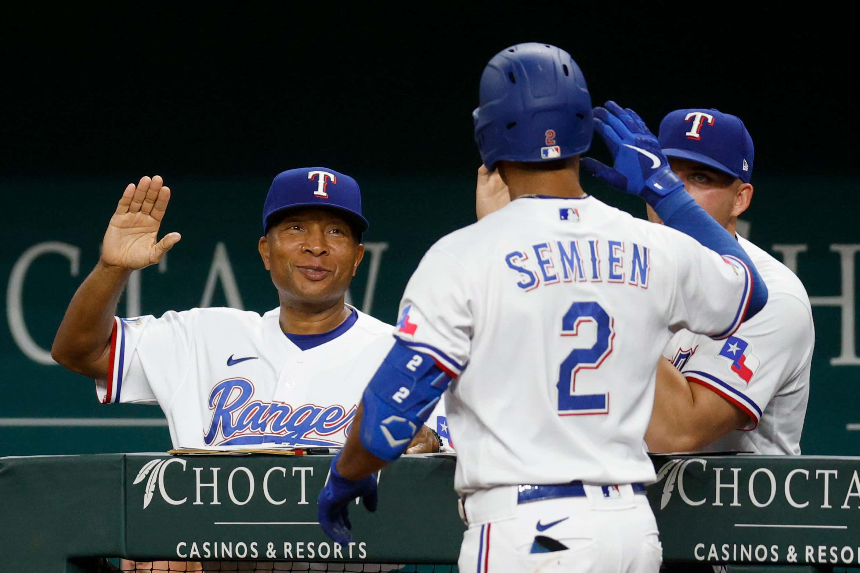 Texas Rangers second baseman Marcus Semien (2) high-fives interim manager Tony Beasley (27)...