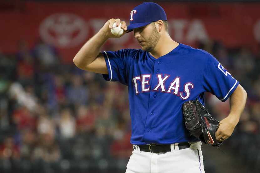 Texas Rangers relief pitcher Shawn Tolleson adjusts his cap as he comes in to pitch the...