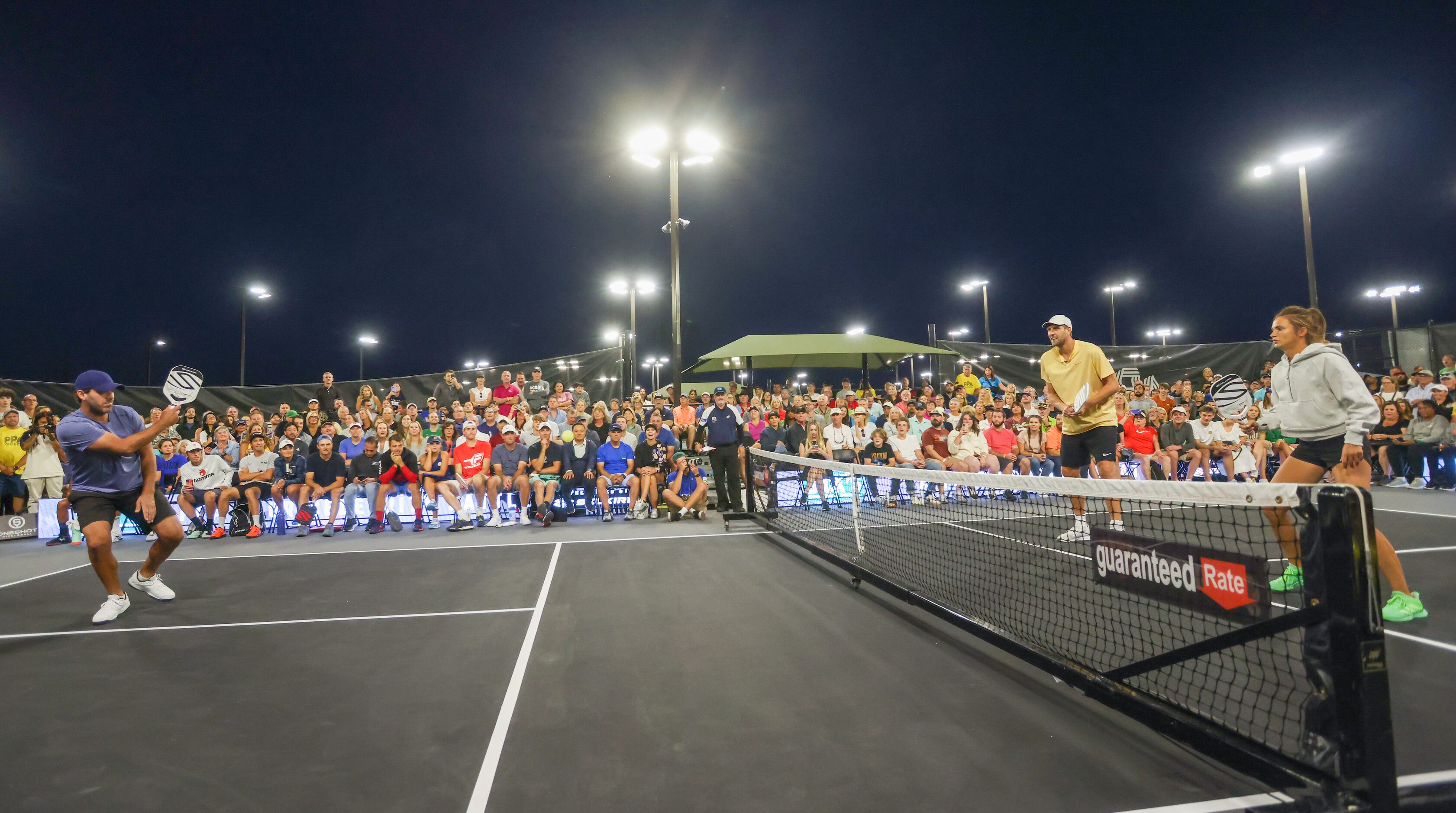 Tony Romo (left), Dirk Nowitzki (center) and Lea Jansen (right) play a match of doubles...