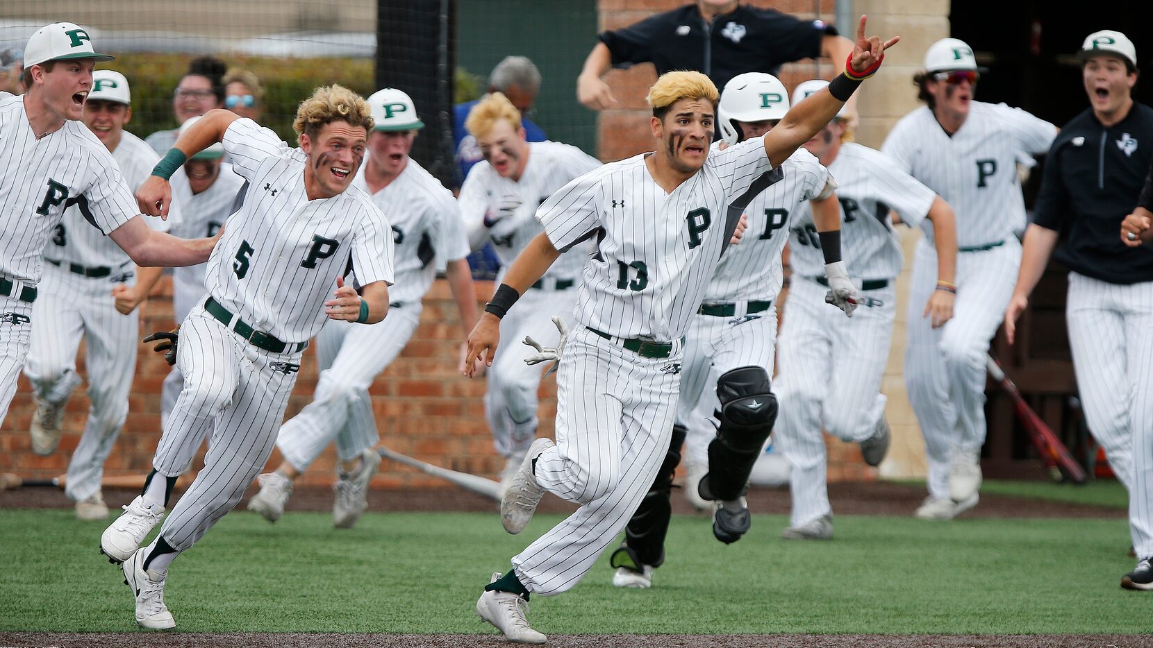 Gabriel Colina (13) leads his team sprinting out of the dugout after completing a come from...