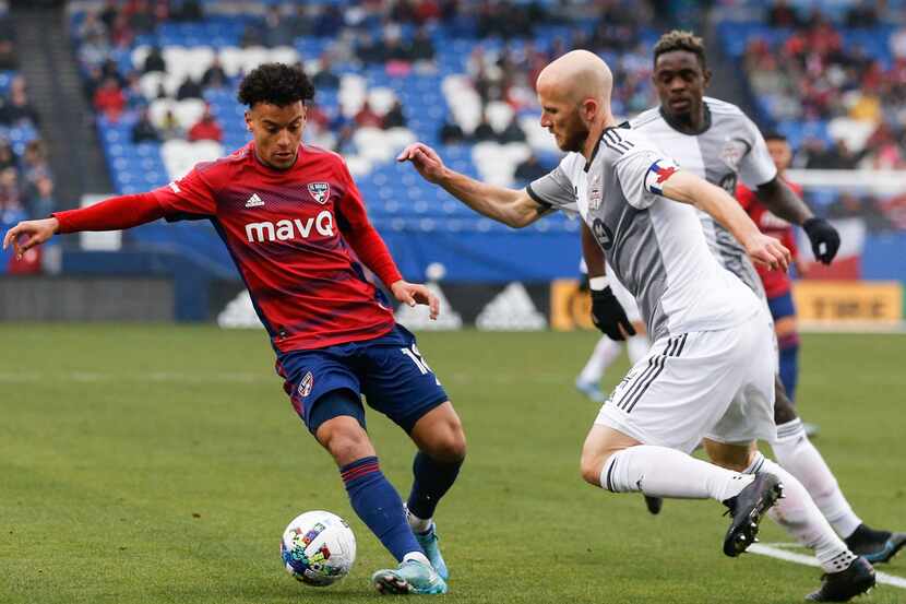 FC Dallas midfielder Brandon Servania (18) keeps possession of the ball from Toronto FC...