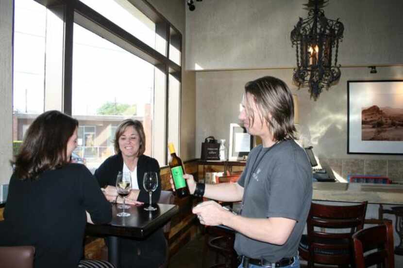 Wine specialist Kyle Sloan (right), talks about the wine selection at Times Ten Cellars with...