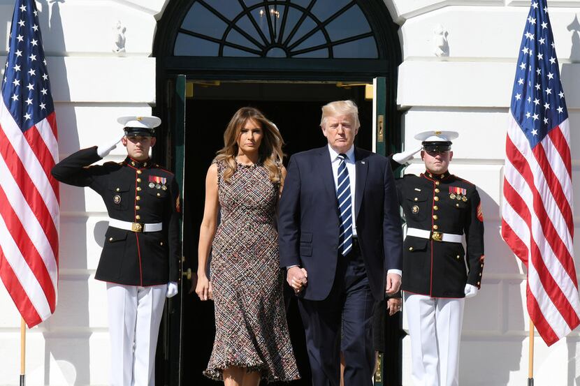 U.S. President Donald Trump and  First Lady Melania Trump walk out of the residence to lead...