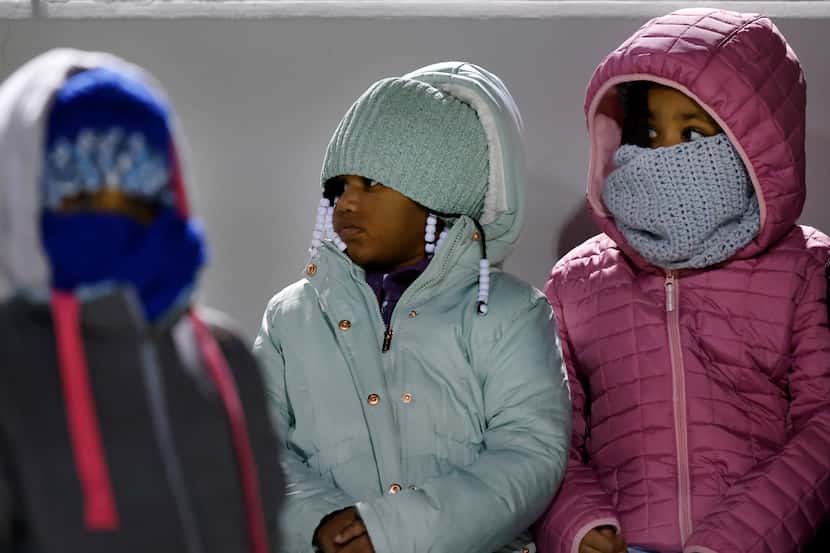 A trio of youngMansfield Timberview fans are bundled up against the cold as their team faced...