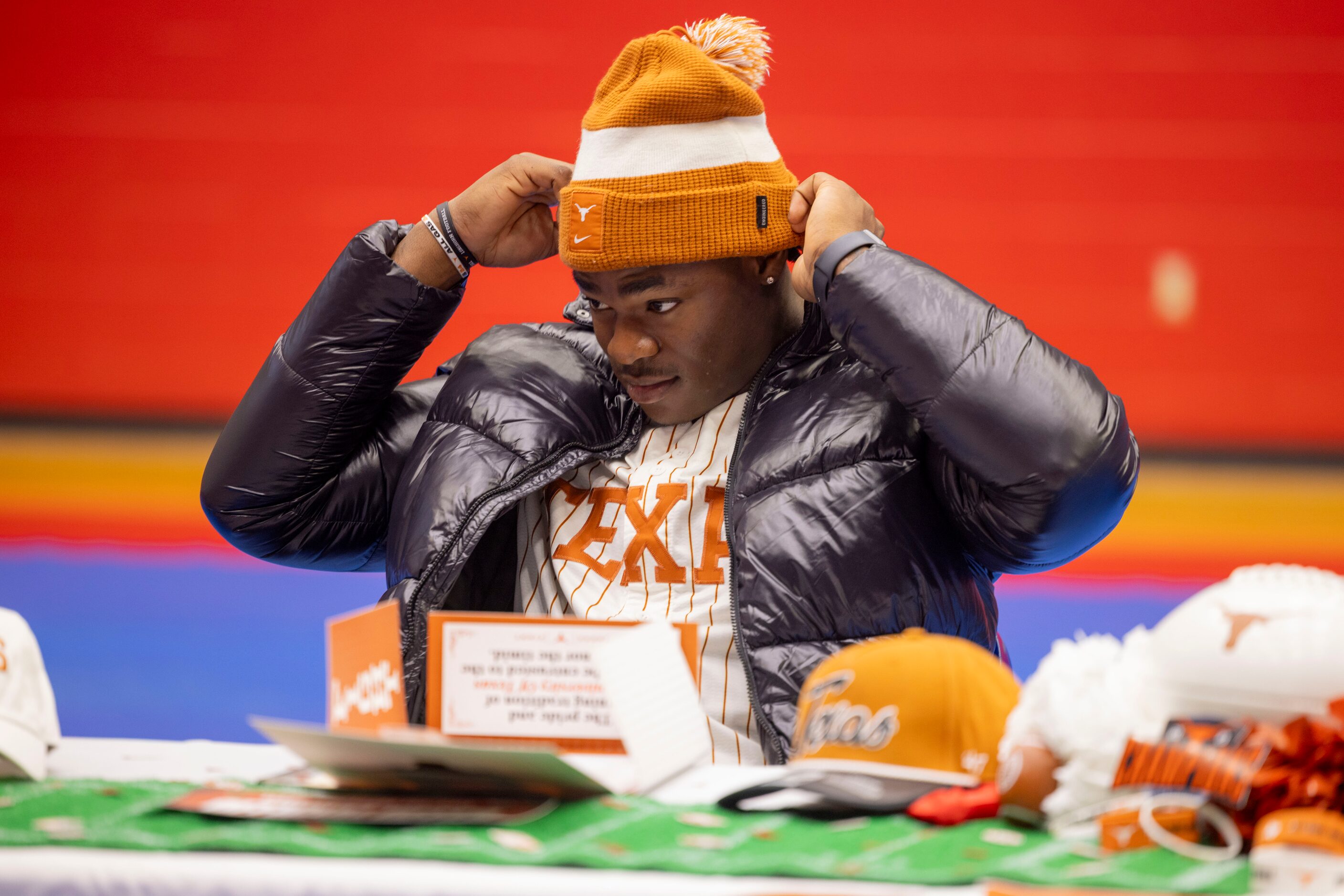 Defensive end Colin Simmons adjusts his beanie before signing his national letter of intent...