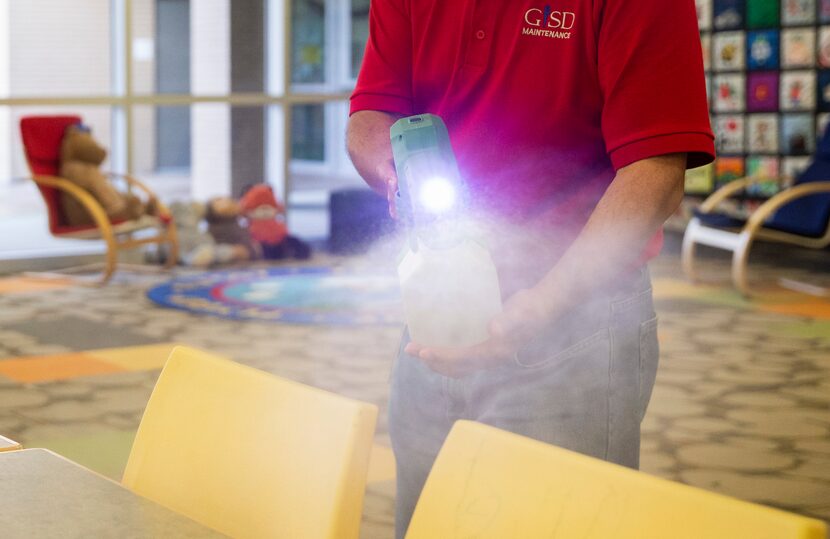 Raul Rodriguez mists the library at Daugherty Elementary School to disinfect it of any...