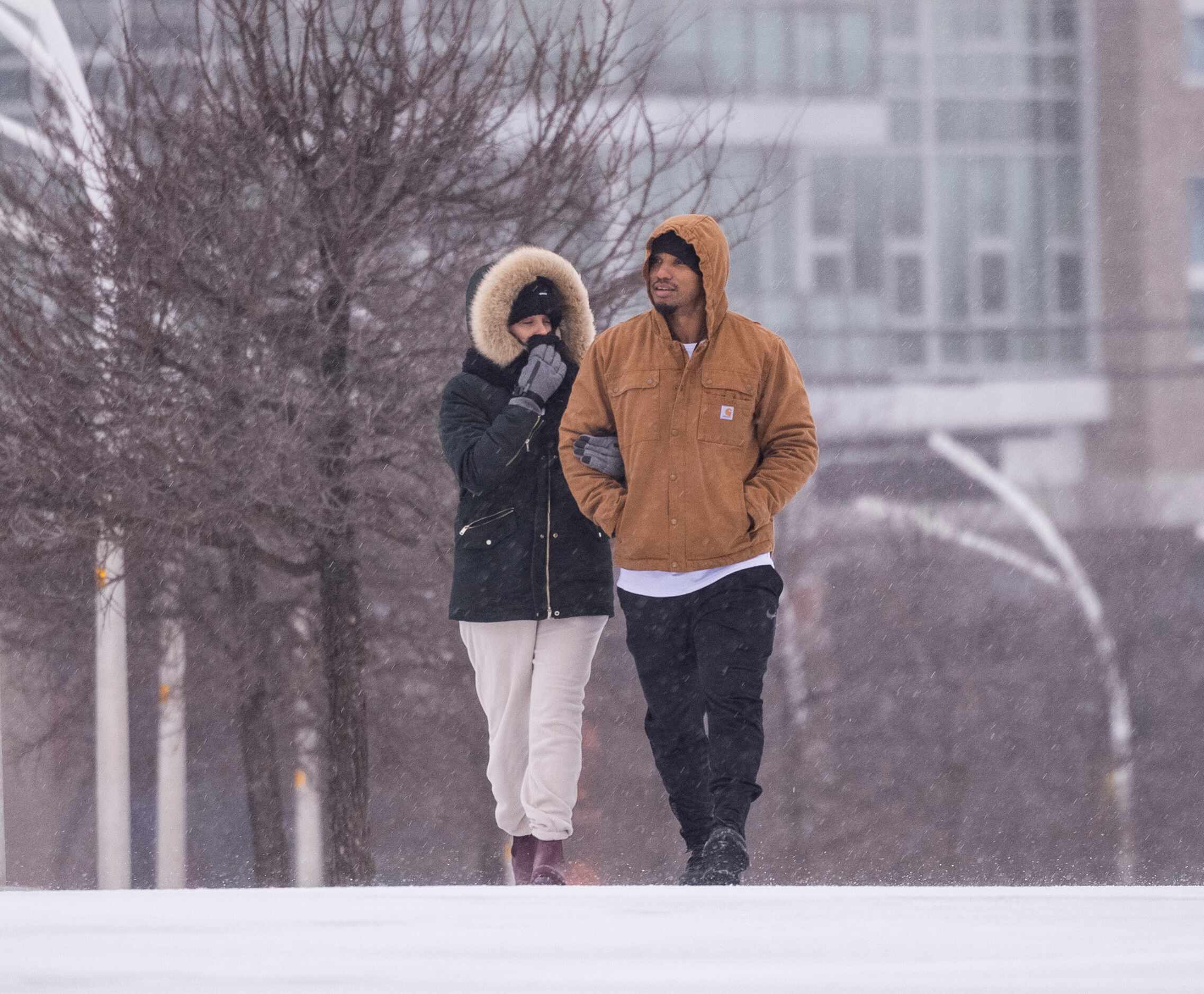 Gabriel Flores (left) and Yadi Ramos walk as sleet falls close to the Margaret Hunt Hill...