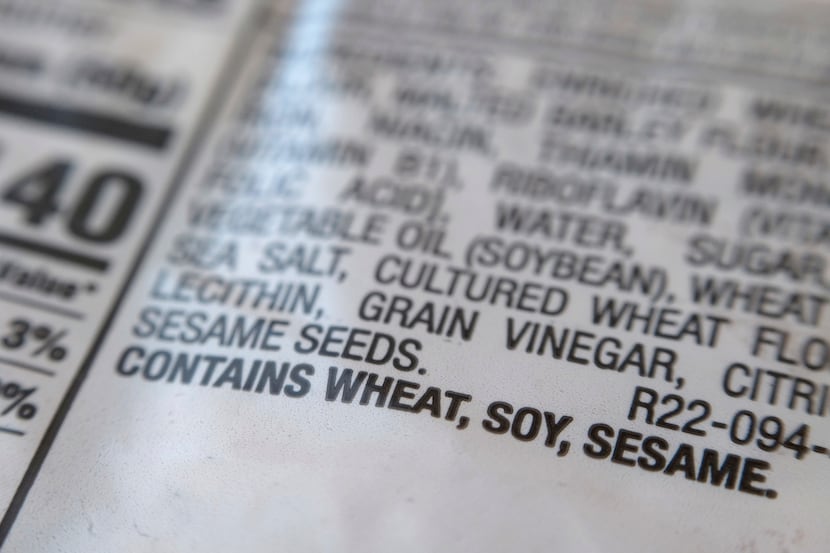 A notification for sesame is printed under the ingredient list on a bag of hot dog buns in...