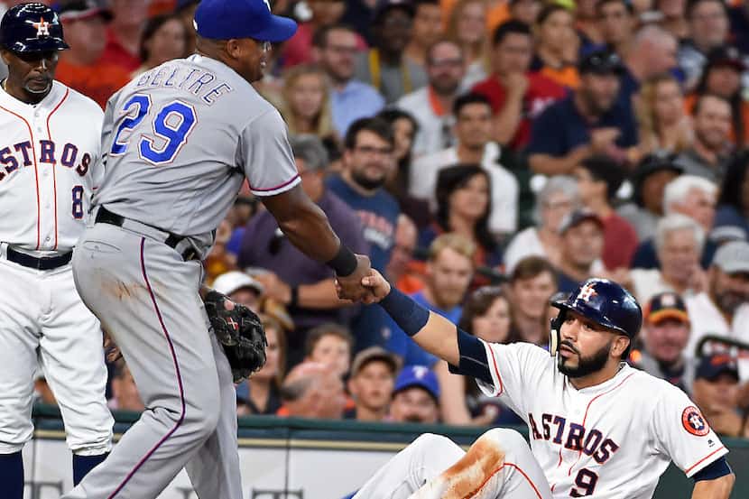 Texas Rangers third baseman Adrian Beltre (29) helps up Houston Astros' Marwin Gonzalez...