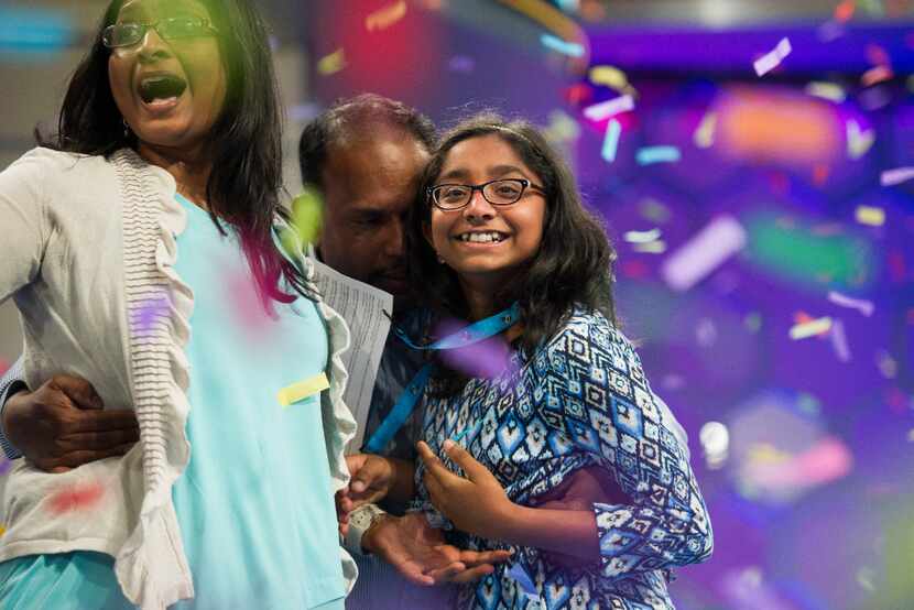 Ananya Vinay, 12, from Fresno, Calif., celebrates onstage with her parents, Anu Pama...