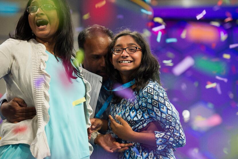 Ananya Vinay, 12, from Fresno, Calif., celebrates onstage with her parents, Anu Pama...