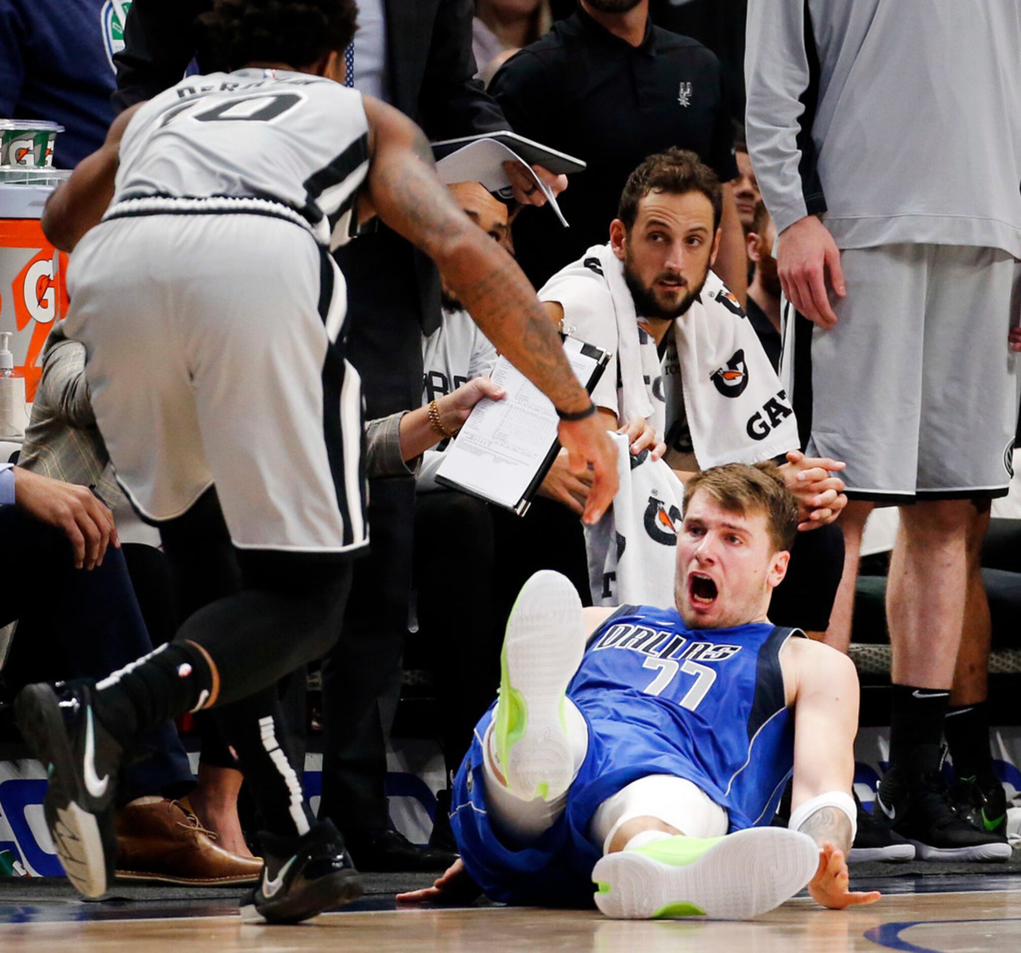 Dallas Mavericks forward Luka Doncic (77) tries to draw a charging foul against San Antonio...