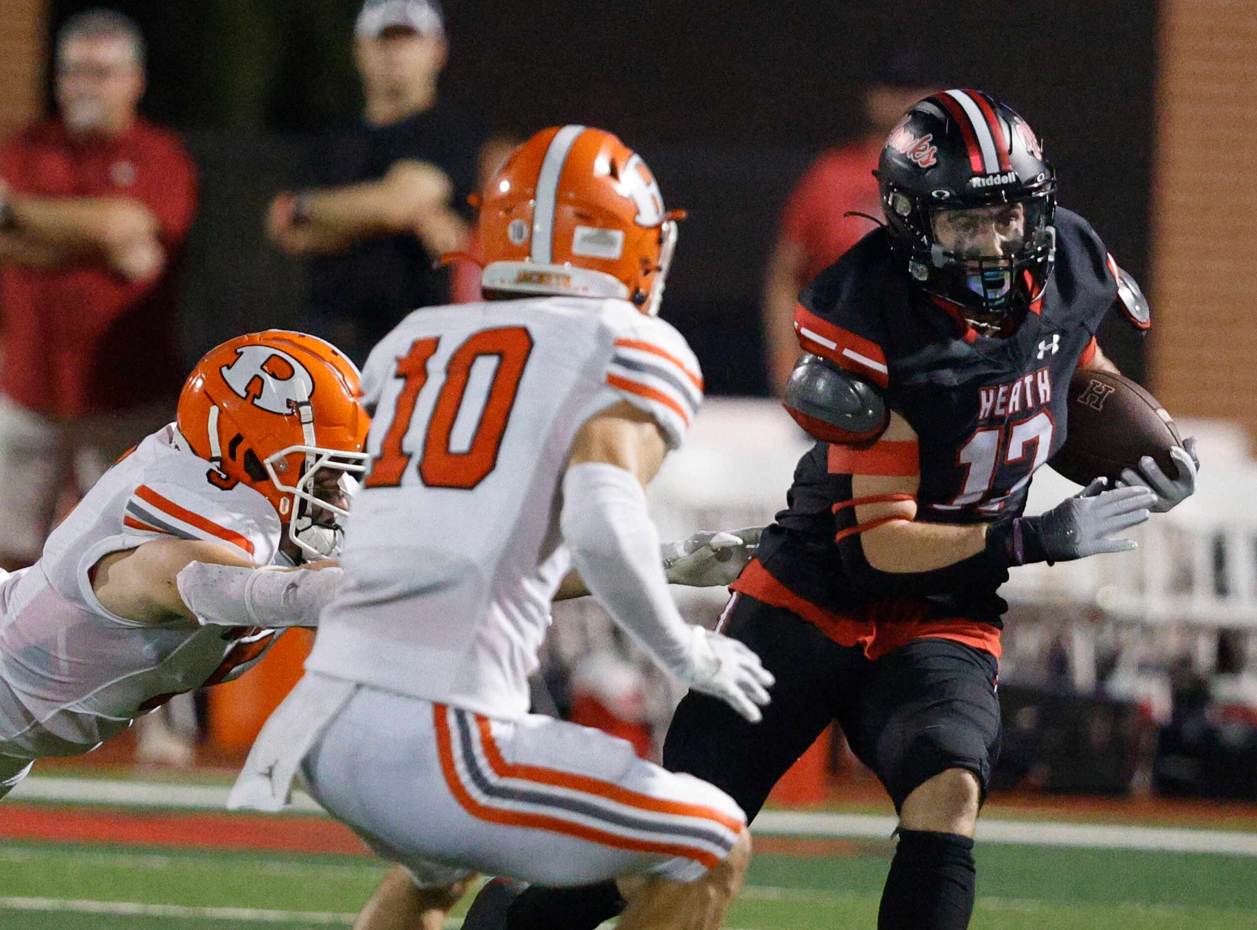 Rockwall-Heath's Jack Davenport (17) carries the ball as Rockwall's Tanner Hart (5) and...