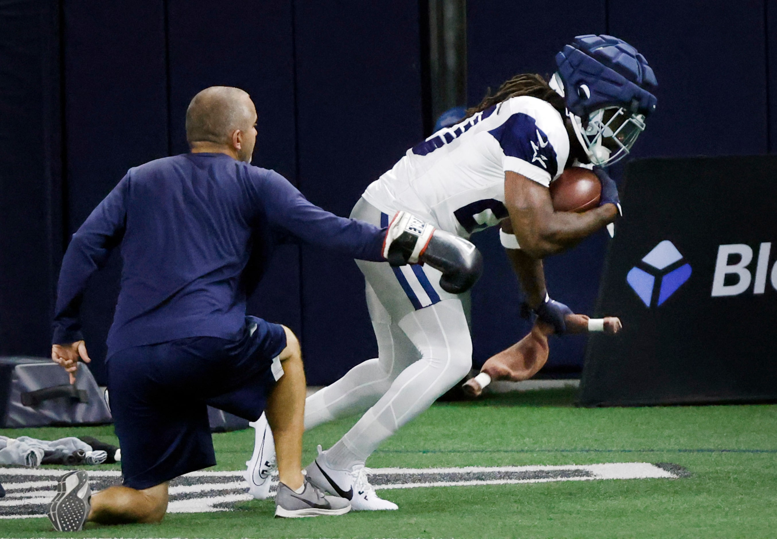 Dallas Cowboys running back Dalvin Cook (20) picks up a towel and his punched as he carries...