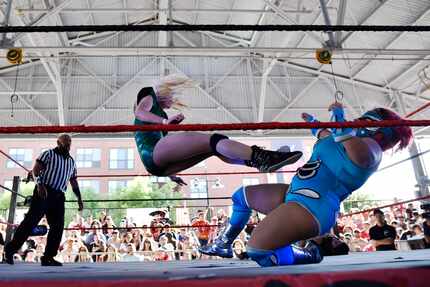 Wrestler Ali Bama, left, flies across the ring as she kicks Dina Mita on her chest during a...