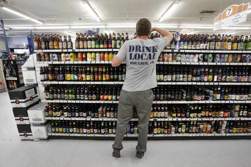Beer manager Kippie Loughlin stocks a shelf with hundreds of varieties of single beers at...