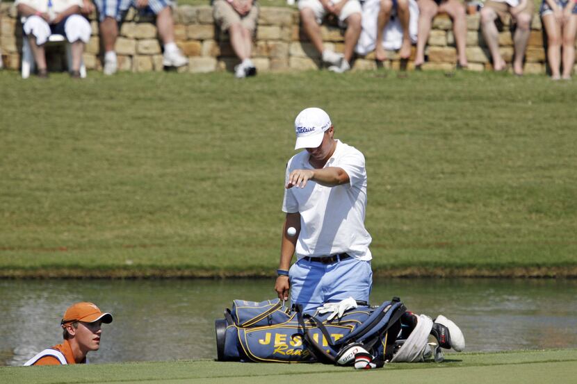 Jordan Spieth takes a drop after hitting a shot into the water off the 18th green during the...