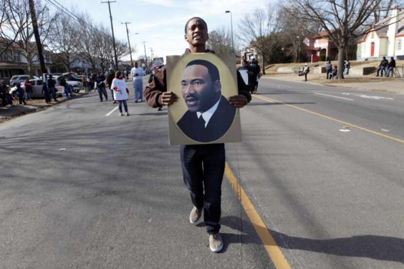 Jordan Young marches with a portrait of Martin Luther King Jr. during a parade on Martin...