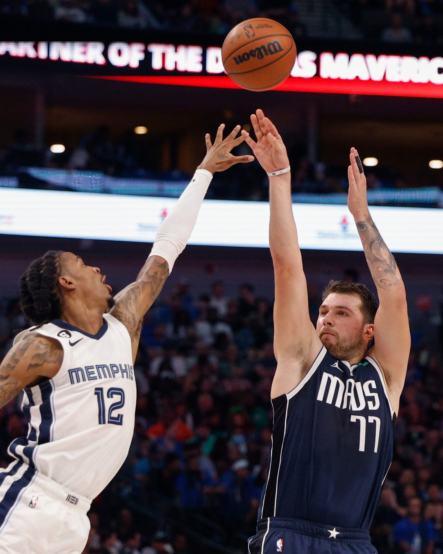 Dallas Mavericks guard Luka Doncic (77) attempts a three-point shot over Memphis Grizzlies...