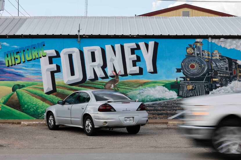 Traffic passes by the Forney sign in downtown Forney in August.