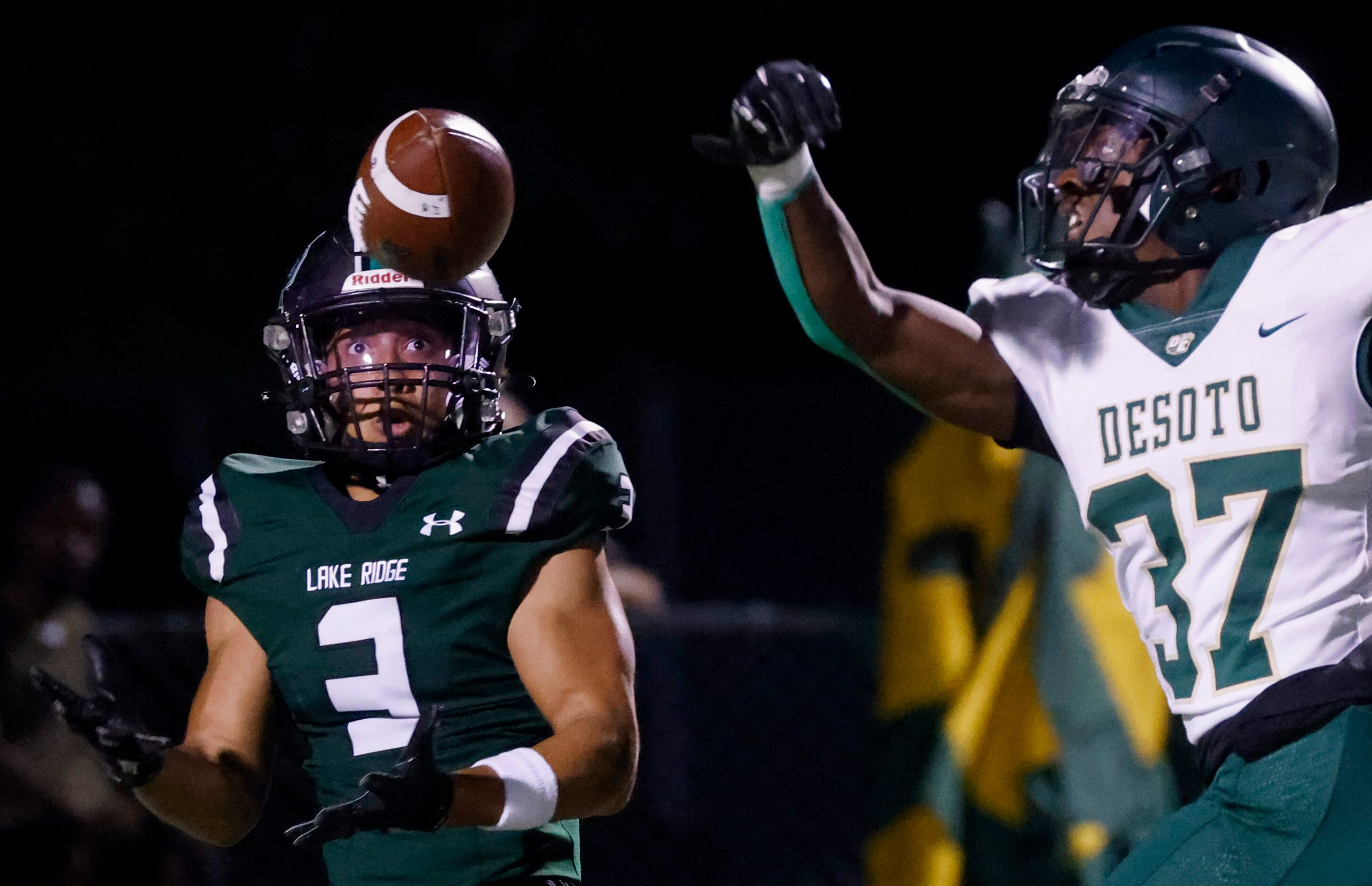 Lake Ridge High School’s Bryce Marcus (3), left, looks as he misses to receive a pass past...