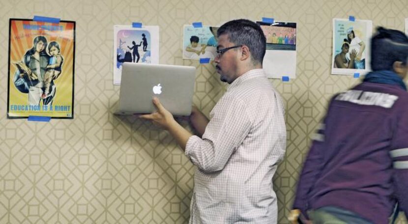 
Arturo Garcia uses his computer to record posters with a positive message for LGBTQ youths...