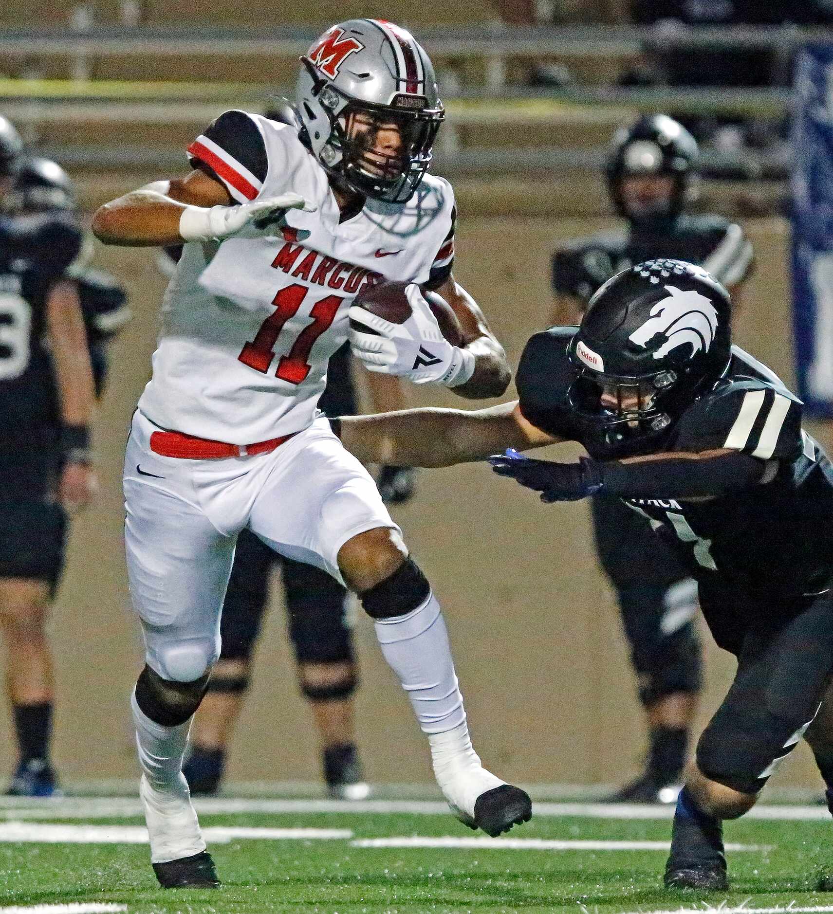 Flower Mound Marcus High School wide receiver Dallas Dudley (11) eludes tacklers for a...