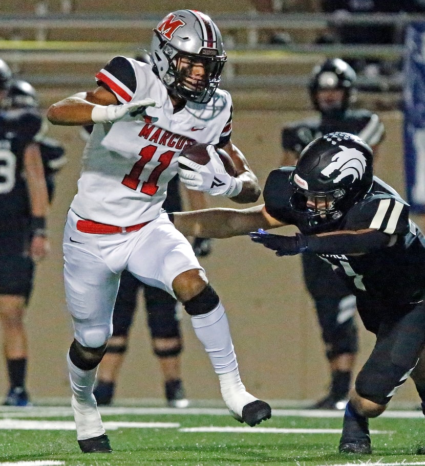 Flower Mound Marcus High School wide receiver Dallas Dudley (11) eludes tacklers for a...