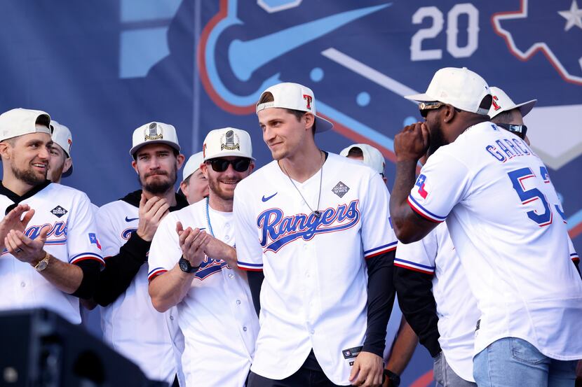 Teammates cheer on Texas Rangers shortstop Corey Seager as steps to the microphone during...