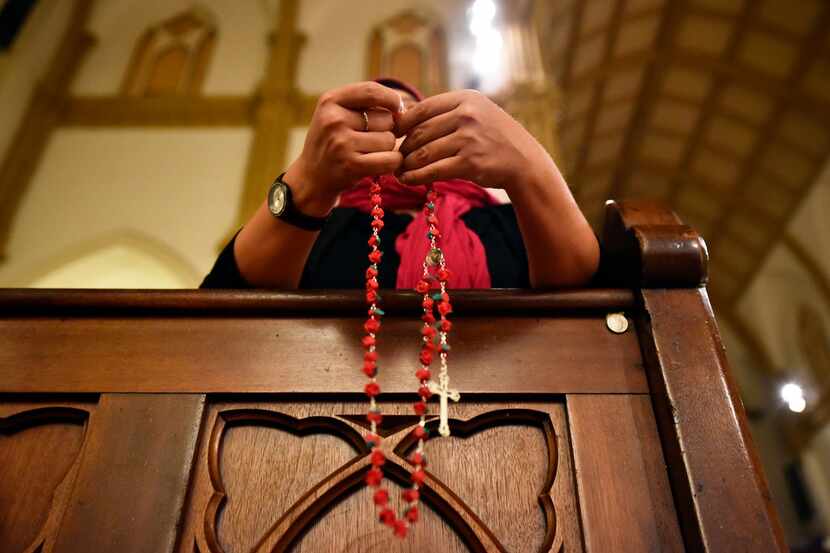 Lisette Moreno, 32, a Mexican-native and believer in Our Lady of Guadalupe, holds a rosary...
