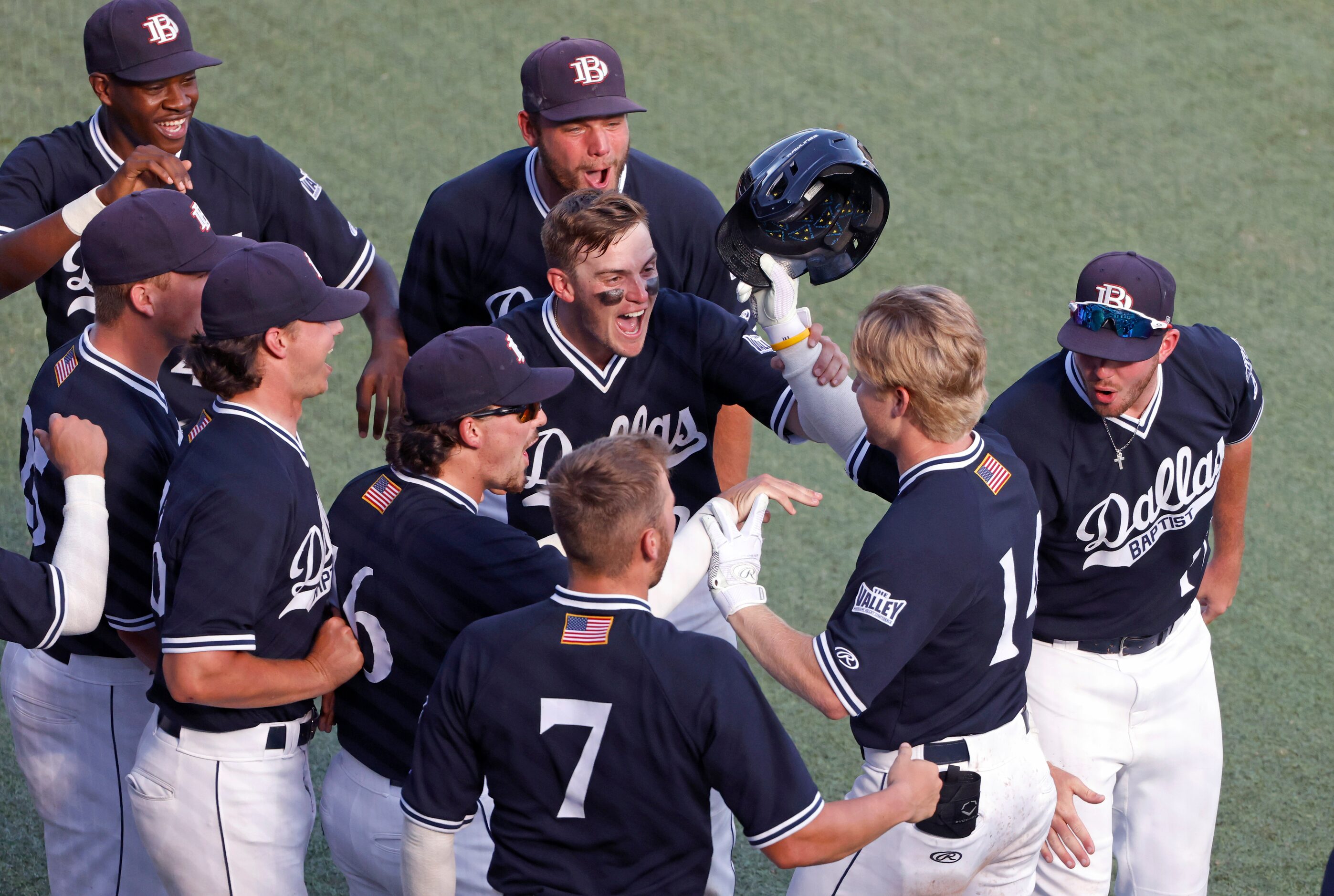 Dallas BaptistÕs River Town (14) celebrates with teammates  after hitting a two-run home...