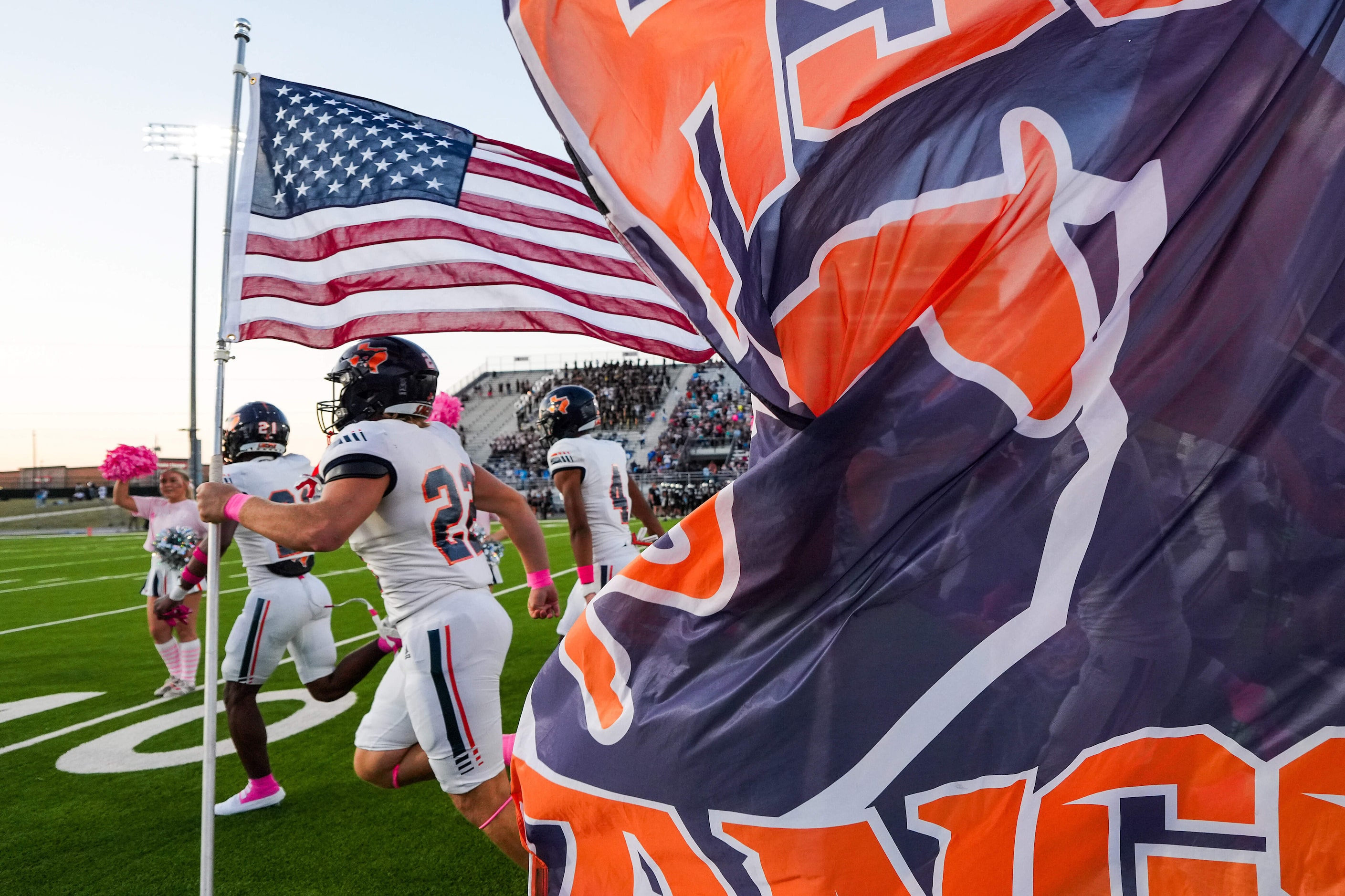 Sachse’s Sean Davault (22) carries the American flag as the team takes the field before a...