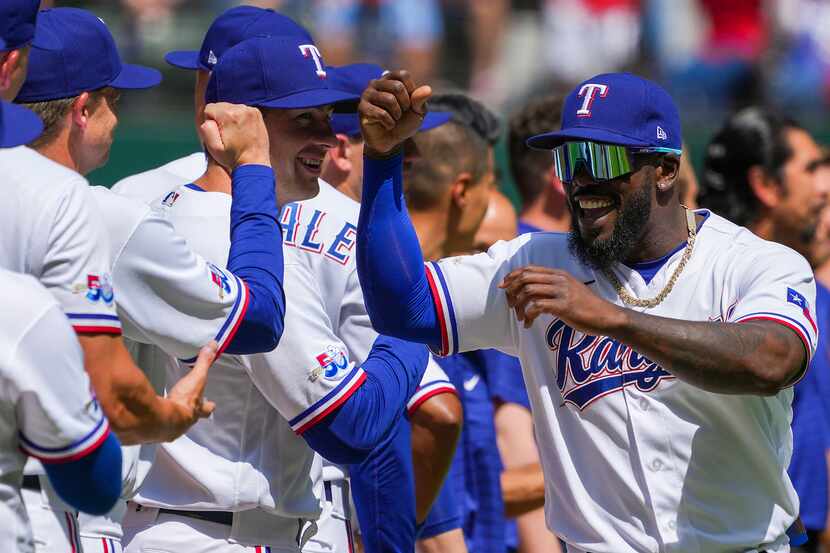 Texas Rangers center fielder Adolis Garcia fist bumps teammates as the team is introduced...