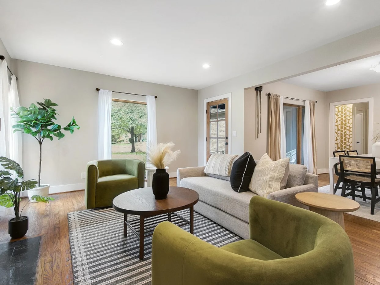 Living and dining rooms with large windows and a striped rug