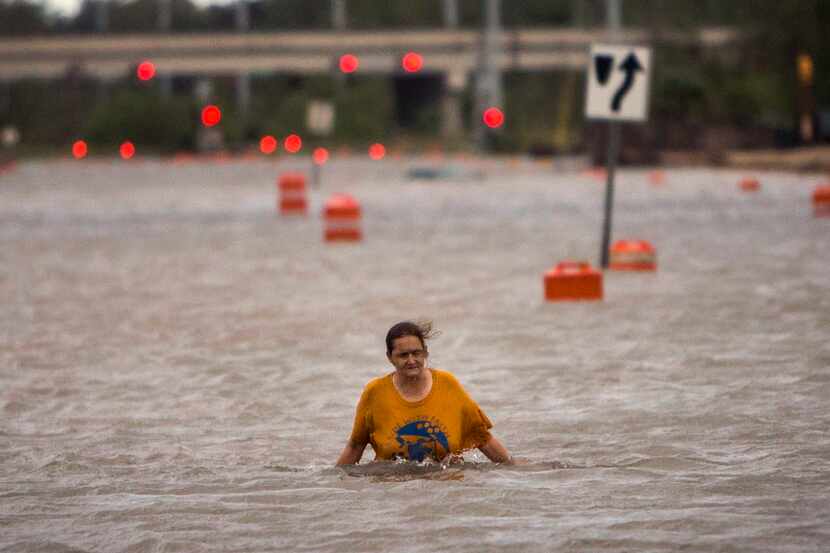 A woman who identified herself as Valerie walks along flooded President Street after leaving...