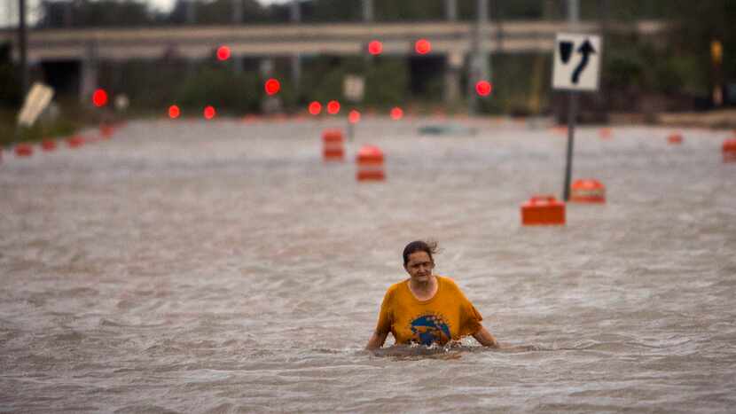 A woman who identified herself as Valerie walks along flooded President Street after leaving...