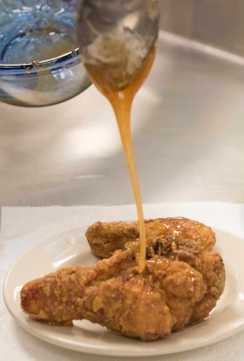 
A sauce made of honey and cayenne pepper is poured on to fried chicken by a culinary...