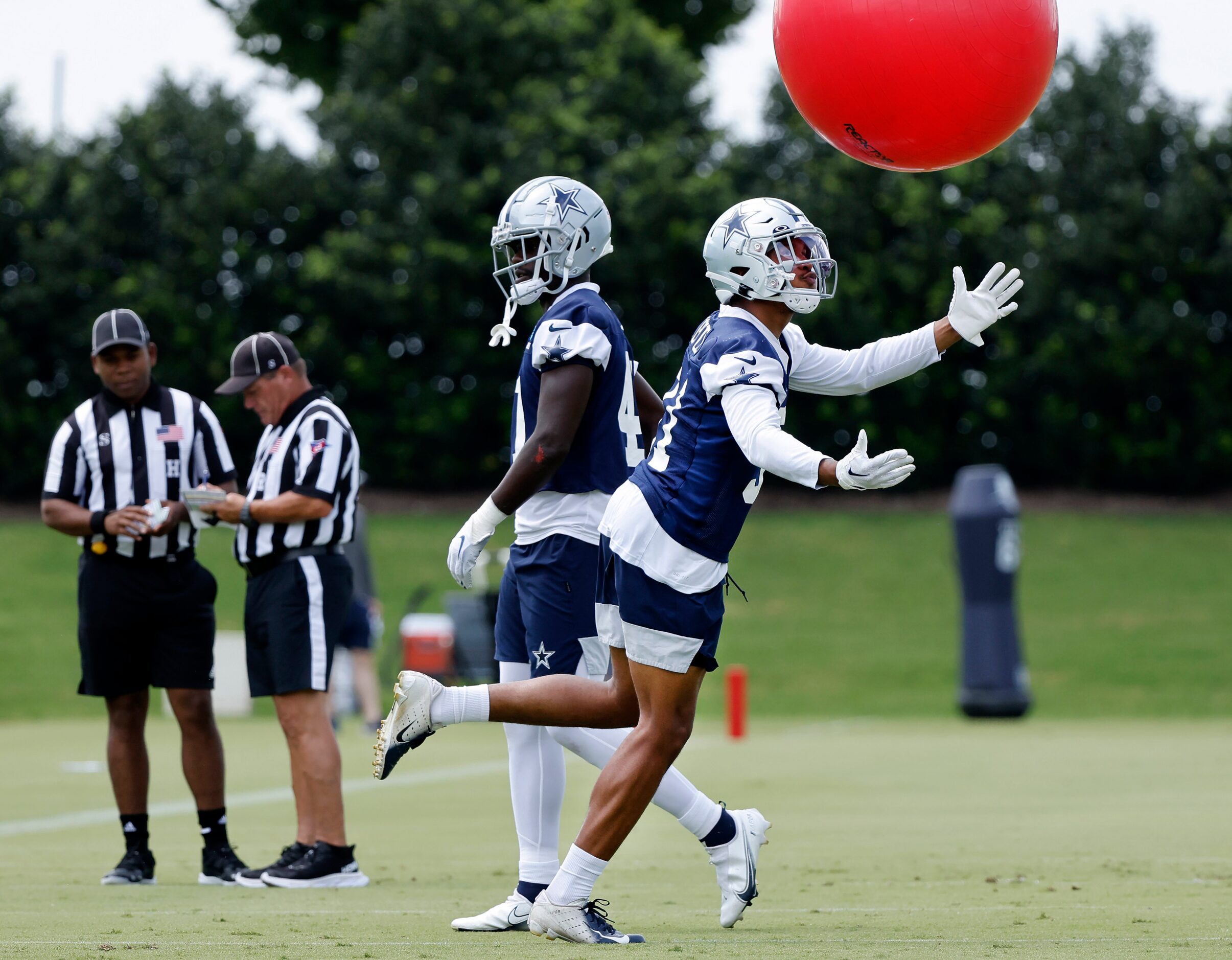 Dallas Cowboys practice squad safety Tyler Coyle (31) scoops up an exercise ball during a...