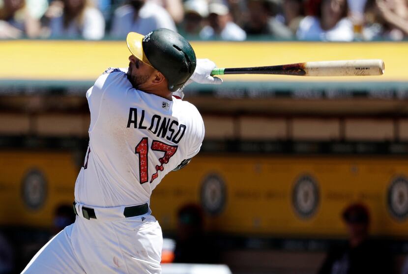 Oakland Athletics' Yonder Alonso follows through with a two-run home run against the Chicago...