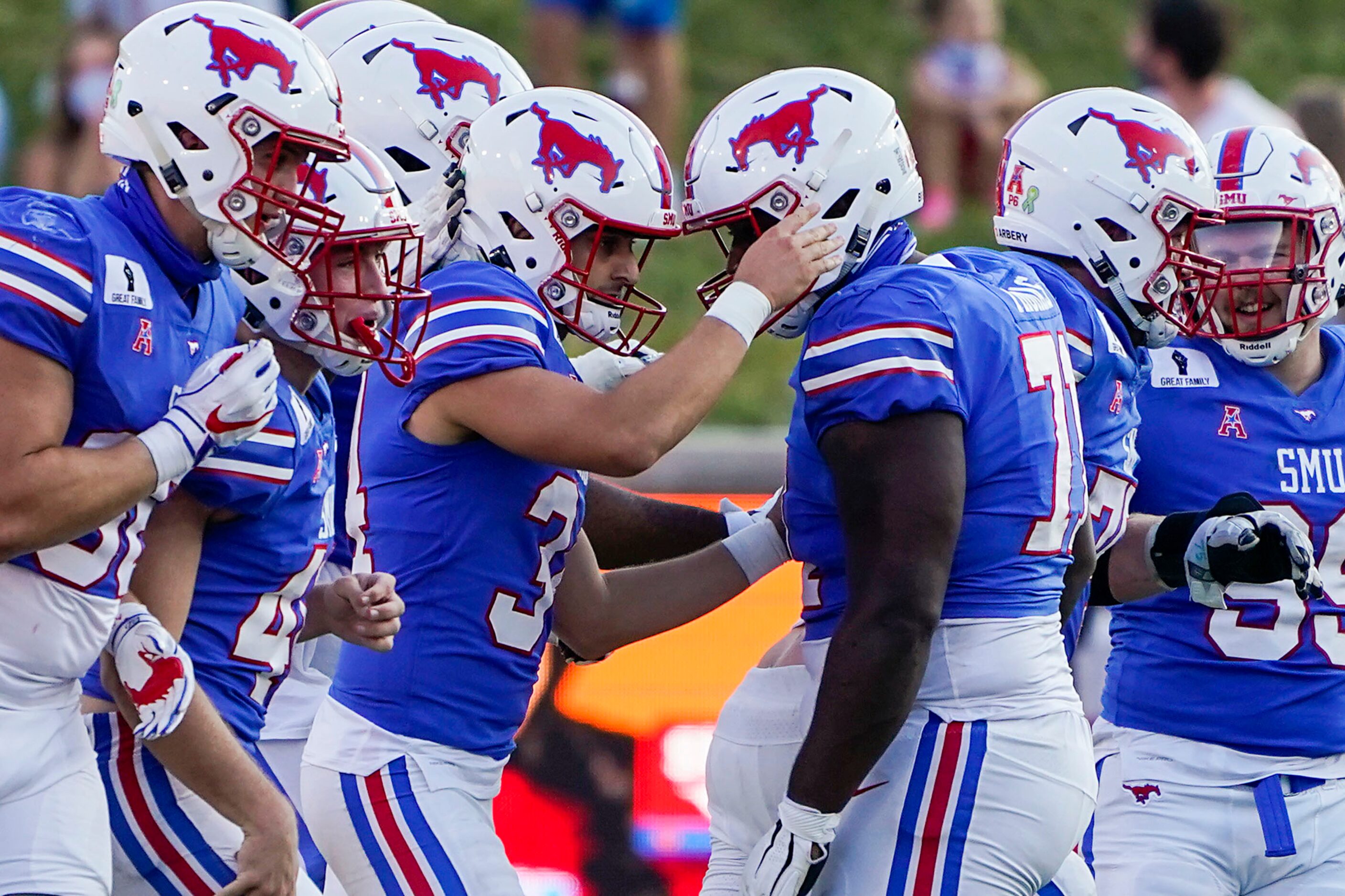 SMU place kicker Chris Naggar (34) celebrates with offensive lineman Jaylon Thomas (71)...