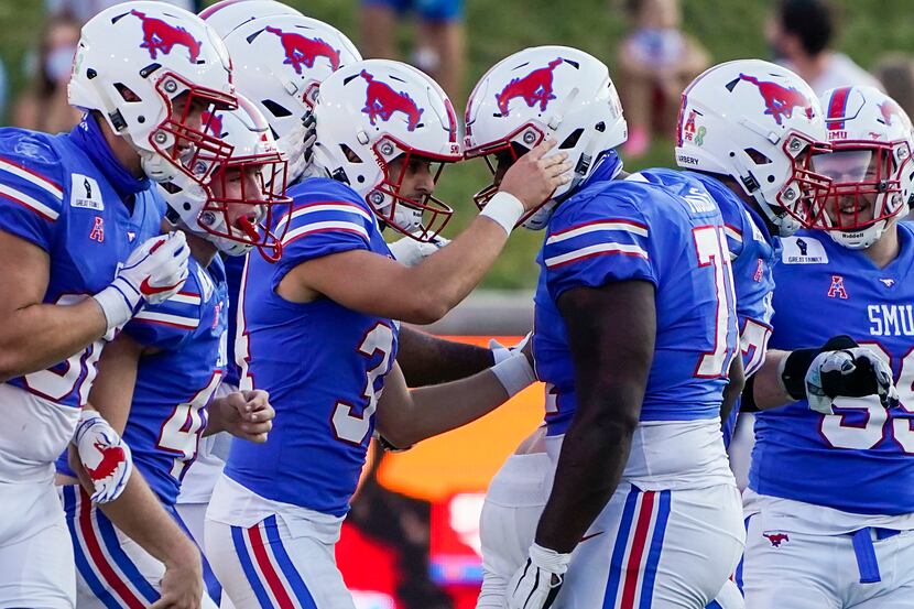 SMU place kicker Chris Naggar (34) celebrates with offensive lineman Jaylon Thomas (71)...