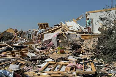A woman stands in a damaged home on Sunday, May 26, 2024, in Celina, Texas, after a tornado...