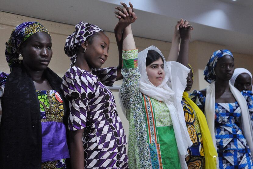 Pakistani activist Malala Yousafzai, center, raises her hands with some of the escaped...