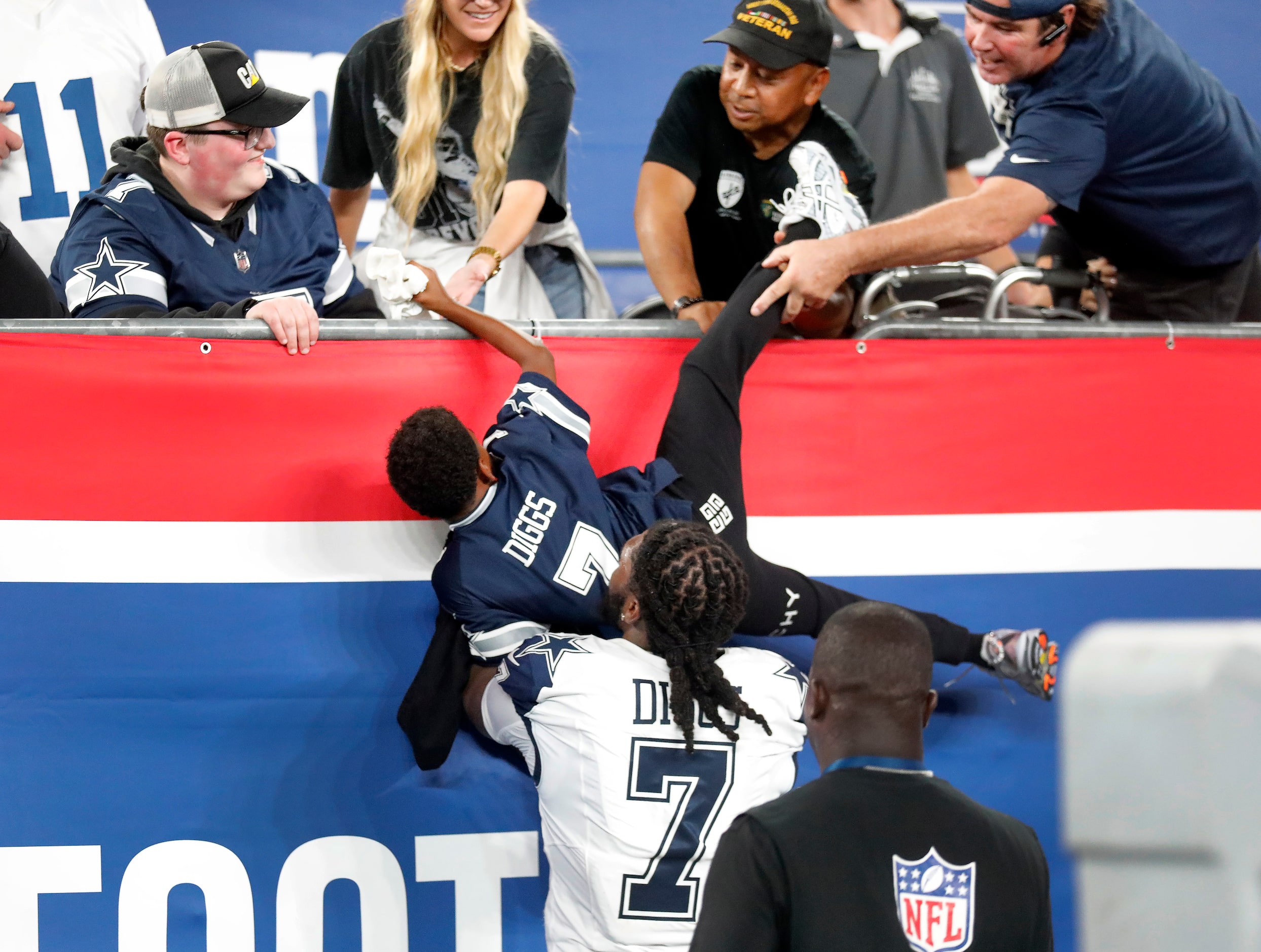 Dallas Cowboys cornerback Trevon Diggs (7) catches his son Aaiden Diggs who climb from the...