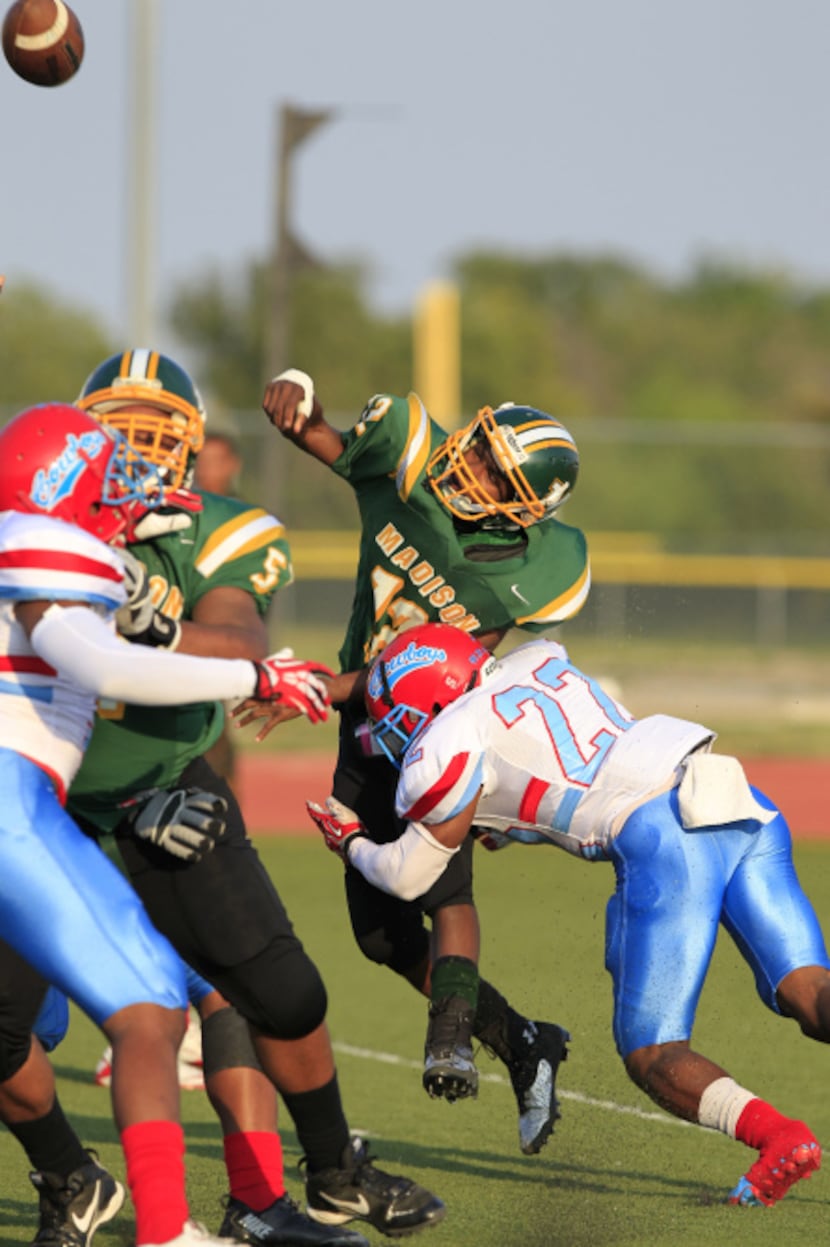 Dallas Madison QB Draylon Jefferey (12) is pounded by Dallas Carter High defender Francisco...